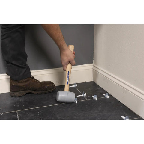 Person using Built Tough Heavy Duty Solid Rubber Mallet With 20 Oz Head And Hardwood Handle Made In The USA for tile work