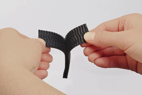 Hands holding Beefy Black Scotch Extreme Fasteners 10 Ft By 1 In Heavy Duty Velcro Bond That Grips Up To 10 Lbs, weatherproof