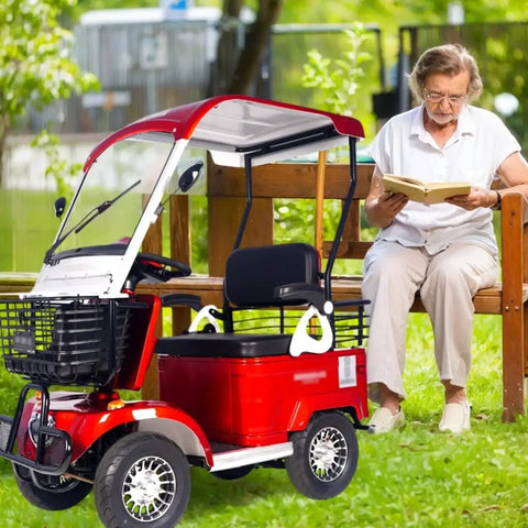 No Sweat Electric Mobility Scooter For Adults And Seniors With 28 Mile Range And 12 Mph Top Speed Hella Tough Frame parked near a reading woman.