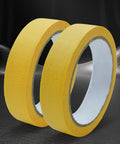 Premium Automotive Painters Paper Tape For Car Detailing And Auto Body Work Straight Up No Burn Surface Guard shown in two rolls on dark background.