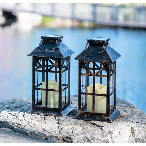 Bronze Hanging Solar Lanterns Two Pack Outdoor Waterproof Decorative Lanterns With Cozy Flickering LED Candles by a lake.