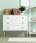 Antique Brass Round Cabinet Knobs 6 Pack on white dresser in modern minimalist room.