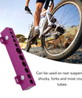Pro Grade All Purpose Bicycle Vise Jaw Set for 5-16mm forks, shocks, and tubes with a white bicycle background, shown on a workbench.