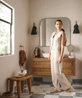 Weymouth Brushed Gold Bathroom Towel Ring For Hand Towels with Concealed Mount visible by the mirror with woman in beige outfit