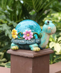 Garden Turtle Statue Outdoor Decor Resin Figurine with Glass Solar Lights on a fence post in a garden setting.