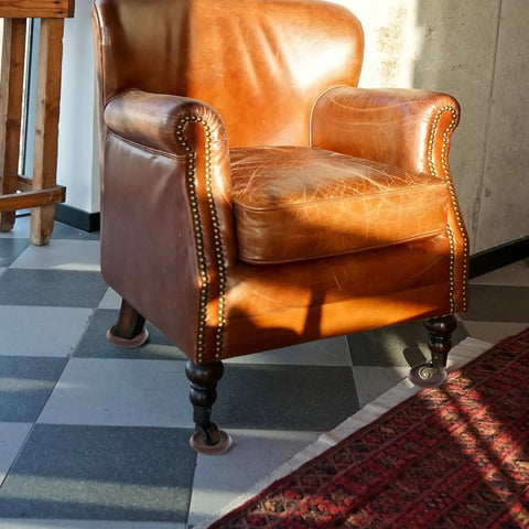10 Pack Furniture Caster Cups With Plush Felt Bottom Anti Skid Floor Savers under a brown leather armchair in sunlight.