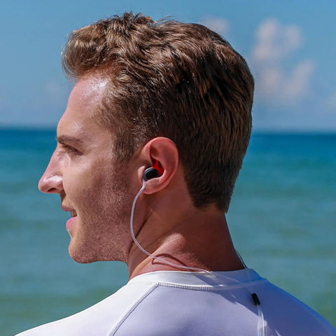 Man wearing Ultimate Swim Ear Plugs For Adults With Safety Cord Waterproof Yet Sound Permeable No More Lost Ear Plugs Perfect For Surfing