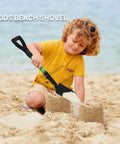 Child uses Kids Beach Shovel For Digging And Gardening 28 Inch Metal Shovel With Short Handle Durable Green on sandy beach