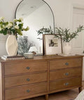 Wooden dresser with vintage mushroom round pulls, featuring Antique Brass Cabinet Knob Set With Backplates, decorated with books and vases.
