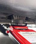 Close-up of rubber jack pad on a red floor jack lifting a vehicle, highlighting Dual Use Lifting Axle Saddle Adapter Pads, 2 Pack For BMW X3 X5 X6 X7 And Mini, No Fuss Fit, Compatible With 4 To 8 Ton Hydraulic Bottle Jacks And Floor Trolley Jacks, 1.42 Inch Recess, Rubber Jack Pad Pucks For Safer, Level Vehicle Lifting.