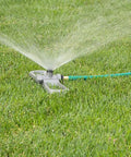 Port-A-Rain Above-Ground Sprinkler System in use, spraying water on green lawn, ideal for flexible yard watering, no-dig setup