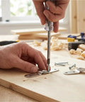 Hand installing Dead Simple Install Iron Folding Table Hinge Chicken Beak Furniture Hardware on wooden surface.