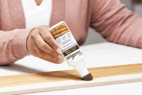 Person applying Less Mess Wood Stain And Applicator All In One 4 Oz Bottle Golden Oak for crafts, enhancing wood grain.