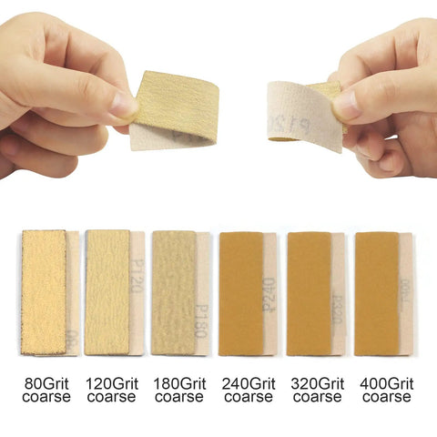 Hands holding sandpaper from Go To 3.5 Inch By 1 Inch Sanding Block With 70 Piece Sandpaper Set In 80 120 180 240 320 400 600 Grit.