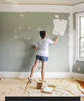 Person painting wall with protection from Canvas Drop Cloth 6x9 Feet Pack Of 2 For Painting And Home Projects Thick All Purpose Cotton Tarp