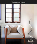Dope 37 Inch LED Spiral Floor Lamp With Curved Modern Design next to armchair in living room, jet black, dimmable lighting.