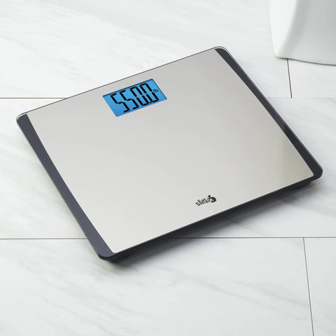Digital Bathroom Scale 550 Pound Capacity With Extra Wide 15 Inch By 13 Inch Platform Stainless Steel Body Step On Technology Large Backlit LCD Readout Fingerprint Resistant Glass Base on a bathroom floor.