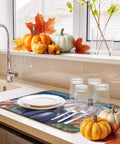 Fall Thanksgiving Dish Drying Mat 16 X 18 Inches with purple pumpkin leaves wood grain design and dishes on a kitchen counter.