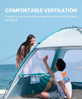 Four Person Beach Tent With Easy Pop Up Setup Shade Shelter, two people enjoying mesh windows for airflow on a beach.