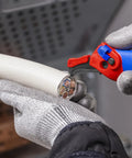 Ratcheting Cable Stripping Knife For Electricians With Three Cutting Areas For Round And Longitudinal Cuts Guide Shoe Protects Insulation Five And Three Quarters Inch Blade Heavy Duty Workhorse Multifunction Tool in use for cable stripping