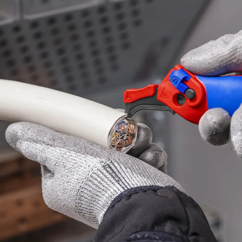 Ratcheting Cable Stripping Knife For Electricians With Three Cutting Areas For Round And Longitudinal Cuts Guide Shoe Protects Insulation Five And Three Quarters Inch Blade Heavy Duty Workhorse Multifunction Tool in use for cable stripping