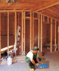 Worker holding a Pack of 4 Saf-T-Braces for Ceiling Fans with 3 Teeth Twist and Lock Silver Finish in unfinished room.