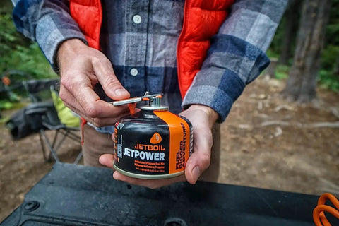 Person holding Jetpower Fuel Canisters For Camping Stoves Two Pack 100 Gram Iso Butane Propane Mix for backpacking and cold weather.