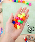 Hand holding colorful bike spoke beads from Colorful Bike Spoke Beads Kit 144 Pcs Of Glow In The Dark Spoke Lights And Clips