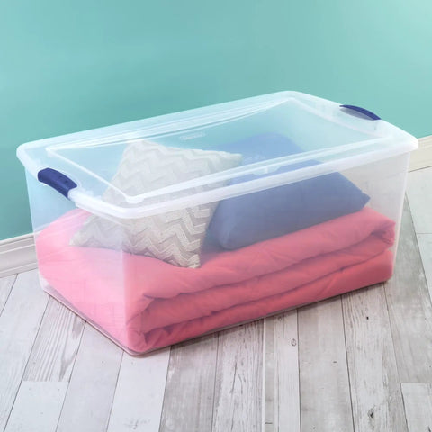 Super Size 105 Quart Clear Plastic Storage Bin With Blue Latching Lid For Big Hauls And House Decluttering with blankets and pillows.