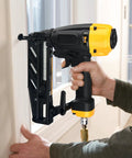 Lightweight 16 Gauge Finish Nailer With Magnesium Housing for Durable Framing in use on a window frame by a person.