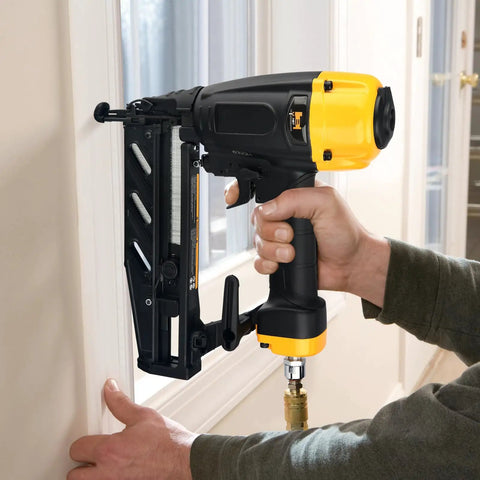 Lightweight 16 Gauge Finish Nailer With Magnesium Housing for Durable Framing in use on a window frame by a person.