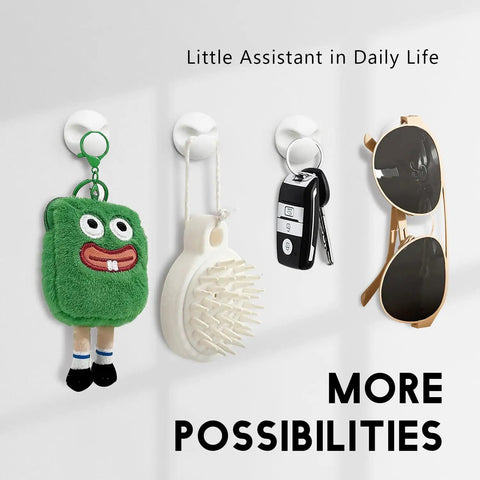 Wall hooks holding a green plush toy, a brush, a key fob, and sunglasses in a row