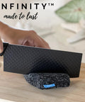 Person cutting Infinity Sponge Odor Resistant And Heat Resistant Silver Fiber Kitchen Cleaning Tool with a knife
