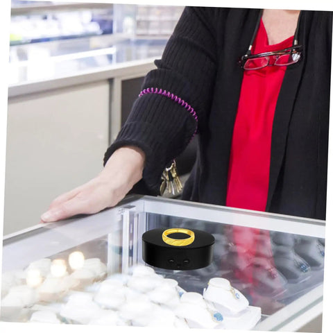 Compact Electric Rotating Turntable Stand For Jewelry Display in a store, showcasing a ring with a 360-degree silent base.