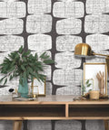 Mid Century Beads Peel And Stick Wallpaper In Black And White on wall behind wooden desk with lamp and plant