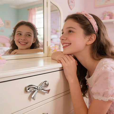 Girl smiling near dresser with Pink And Silver Bow Dresser Knobs For Kids Rooms, Zinc Alloy 3D Decorative Drawer Pulls, ideal for girls' decor