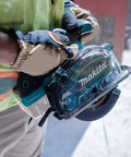 Worker holding 18V LXT Cordless Metal Cutting Saw Bare Tool with 5 3/8 inch cut capacity, ideal for cutting metal on job sites