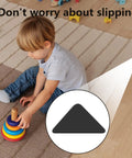 Child playing on a non-slip rug with 8 Piece Triangle Rug Grippers Black Non Slip Rug Corner Holders on hardwood floor