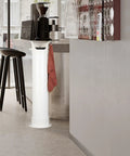 Heavy Duty White Coffee Knock Box And Espresso Dump Bin Featuring Shock Absorbent Base For Fast Grinder Cleanup Removable Liners in a café setting.