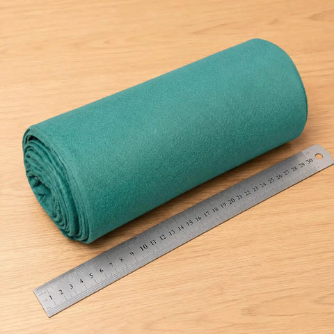 Heavy Duty Polyester Ground Cover Mat With Built Like A Tank Weed Barrier And Water Permeable Drainage Design For Outdoor Landscaping Playground Surface Base Foundation Underlayment rolled with ruler for size reference.