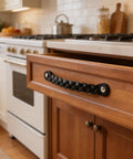 Braided Leather Drawer Pulls Set In Black Six And A Half Inch Length By One Inch Width, installed on a wooden kitchen drawer.