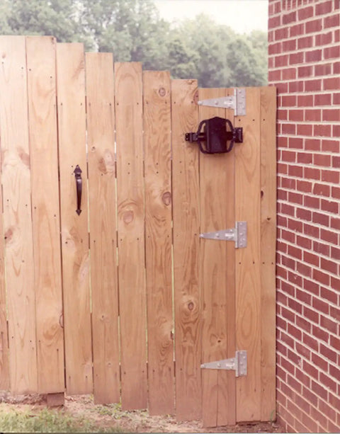 Wooden gate with Hydraulic Gate And Door Closer Self Closing Unit For Indoor And Outdoor Gates Up To 150lbs No Fuss Quiet Smooth Action Patent Pending Cylinder Easy Install Pool Code Compliant mounted next to brick wall.