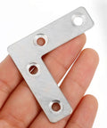 Close-up of Heavy Duty L Shaped Corner Brackets Set, 36 Stainless Steel Mounting Braces for Cabinets and Furniture, Flat Back Design in hand