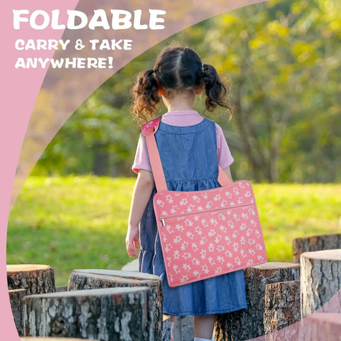 Child outdoors carrying the Kids Travel Tray for Car Seat with Ipad Holder and Dry Erase Board, pink with floral pattern.