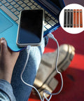 Six Piece Slick Leather Cable Straps For Usb Gadgets And Headphones Black Anti Tangle Wire Ties on a laptop with a phone.