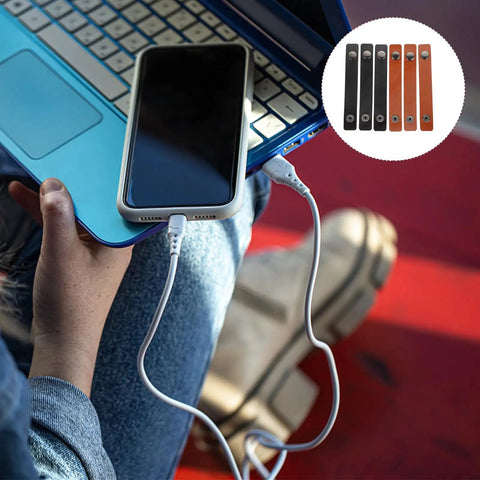 Six Piece Slick Leather Cable Straps For Usb Gadgets And Headphones Black Anti Tangle Wire Ties on a laptop with a phone.