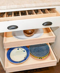 Smooth Glide Pull Out Cabinet Organizer And Slide Out Drawer with contents including plates and utensils in a kitchen drawer.