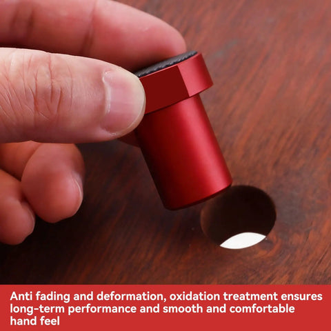 Close-up of a hand placing red aluminum clamp from 12 Piece Aluminum Alloy Bench Dog Clamp Set For MFT Workbenches into a hole