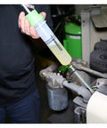 Hand using Compact 200cc Fluid Extractor and Filler Pump for precise fluid transfer in engine bay