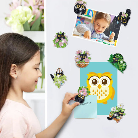 A child placing a magnet from Black Cat Diamond Art Magnets Kit 16Pcs 5D DIY Diamond Painting Magnets on a refrigerator.